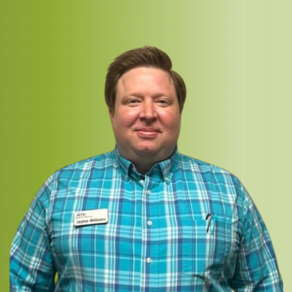 Person wearing a turquoise plaid button-up shirt with a name tag and pen in the pocket, against a green gradient background.
