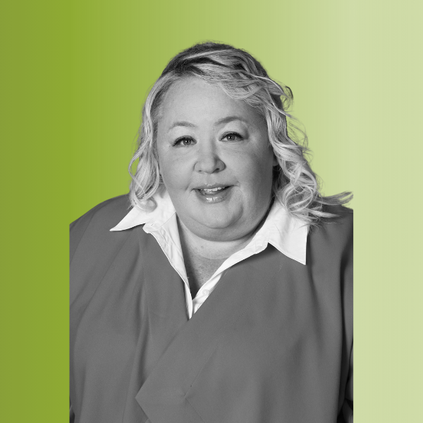 Person in a black-and-white photo wearing a white collared shirt under a dark jacket, with wavy hair, against a green gradient background.