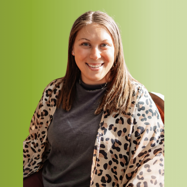 Person wearing a dark gray shirt with a beige leopard-print cardigan, against a green gradient background.
